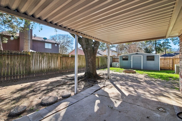 view of patio / terrace featuring a fenced backyard, a fire pit, and an outbuilding