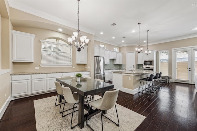 dining area with crown molding, dark wood-type flooring, and a notable chandelier