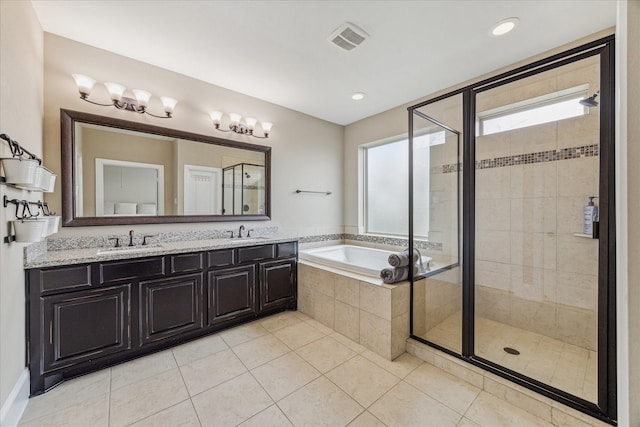 bathroom featuring a bath, a stall shower, visible vents, and a sink