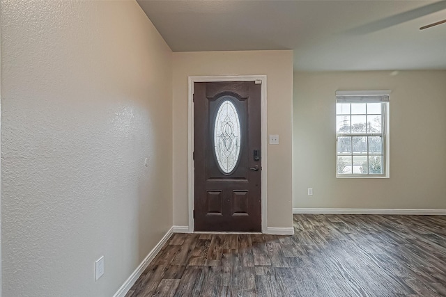 foyer with dark wood-type flooring and baseboards