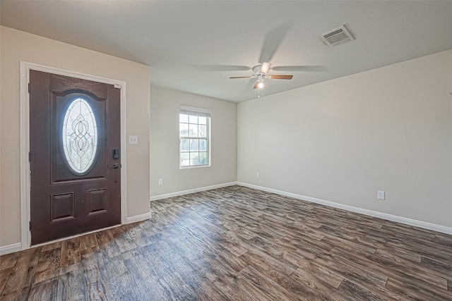 foyer featuring dark wood-type flooring, a ceiling fan, visible vents, and baseboards