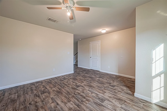 unfurnished room featuring ceiling fan, dark wood-type flooring, visible vents, baseboards, and stairs