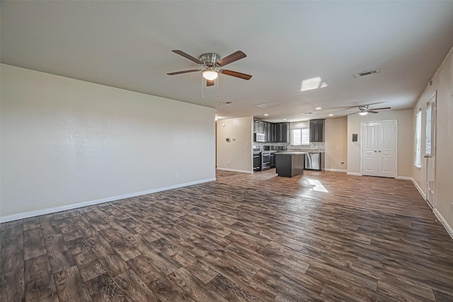 unfurnished living room with ceiling fan, dark wood finished floors, visible vents, and baseboards