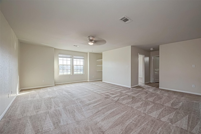 carpeted empty room with visible vents, ceiling fan, and baseboards