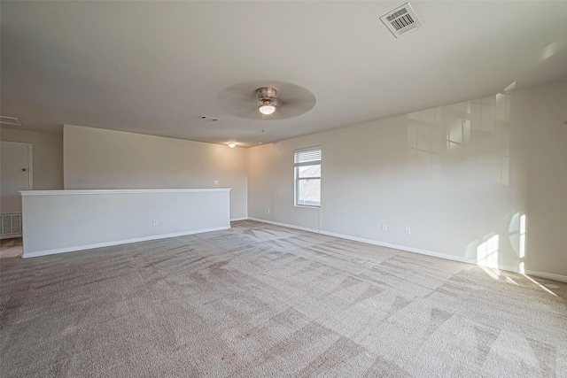 empty room with carpet, visible vents, ceiling fan, and baseboards