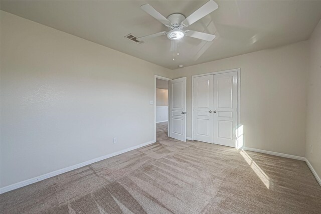 unfurnished bedroom featuring carpet floors, a closet, visible vents, ceiling fan, and baseboards