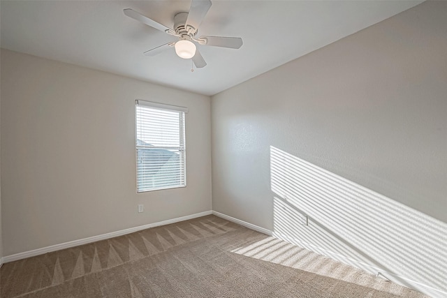 carpeted empty room with ceiling fan and baseboards