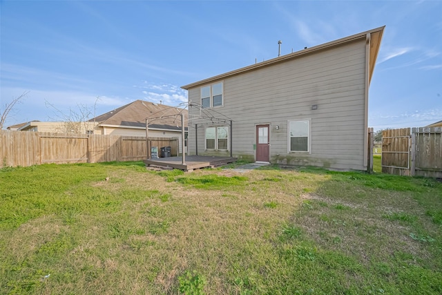 back of house featuring a yard, a fenced backyard, and a wooden deck