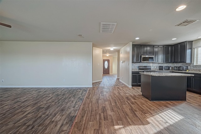 kitchen featuring tasteful backsplash, visible vents, stainless steel appliances, and open floor plan