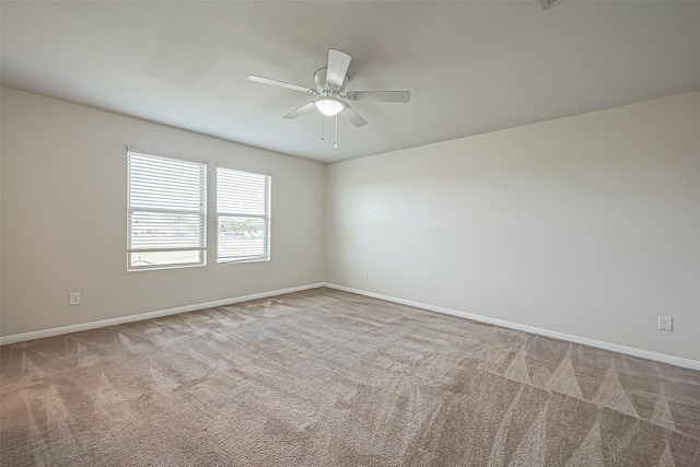 spare room featuring ceiling fan, carpet, and baseboards