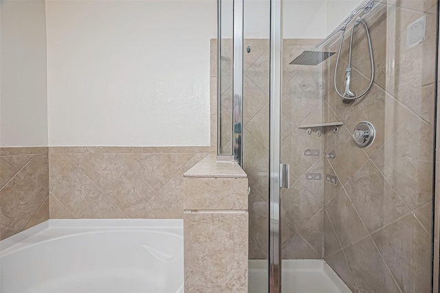 bathroom with a shower stall and a bath