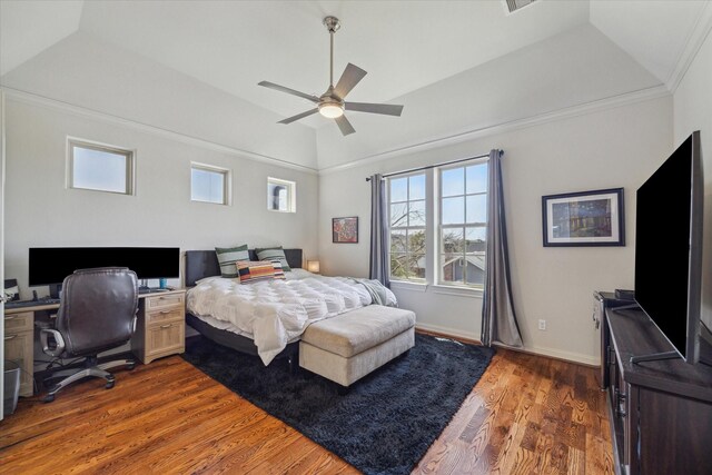 bedroom featuring a tray ceiling, vaulted ceiling, baseboards, and wood finished floors