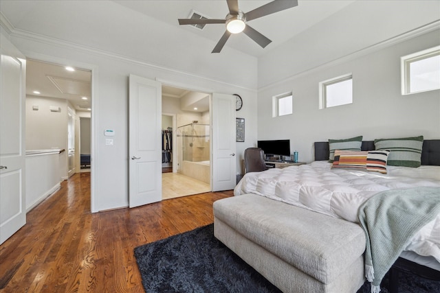 bedroom featuring attic access, a ceiling fan, wood finished floors, and ensuite bathroom