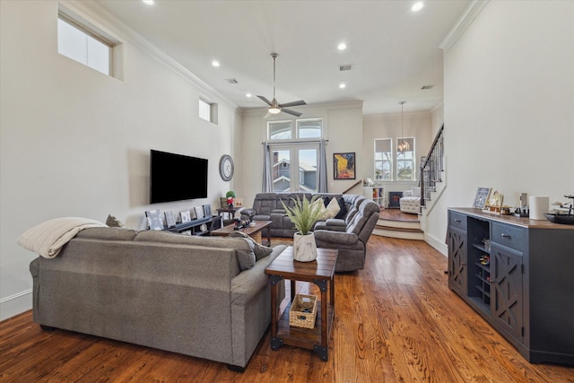 living room with stairs, ornamental molding, and wood finished floors