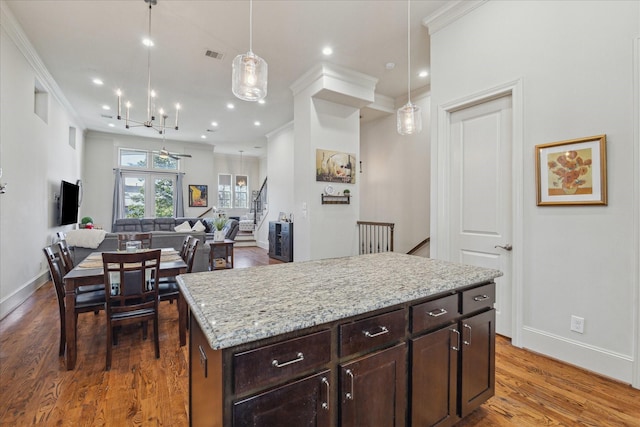 kitchen featuring visible vents, dark brown cabinetry, baseboards, and wood finished floors