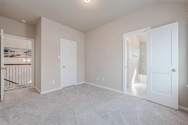 unfurnished bedroom featuring carpet floors, an inviting chandelier, ensuite bathroom, vaulted ceiling, and baseboards