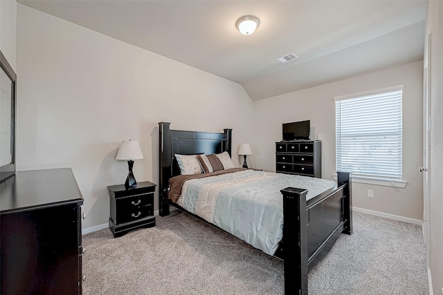 bedroom with visible vents, vaulted ceiling, light carpet, and baseboards