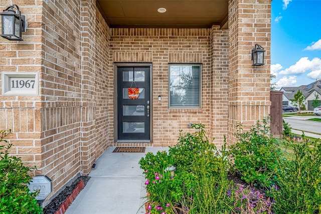 view of exterior entry with brick siding