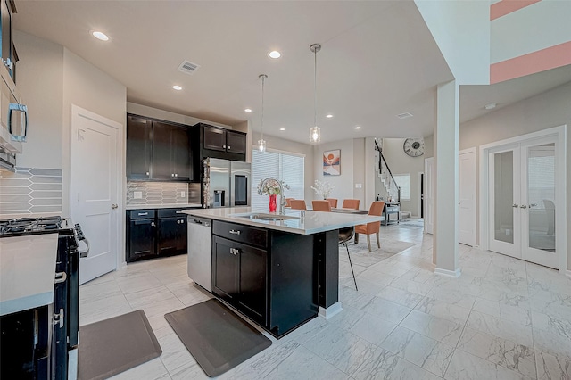 kitchen with marble finish floor, visible vents, decorative backsplash, appliances with stainless steel finishes, and a kitchen bar