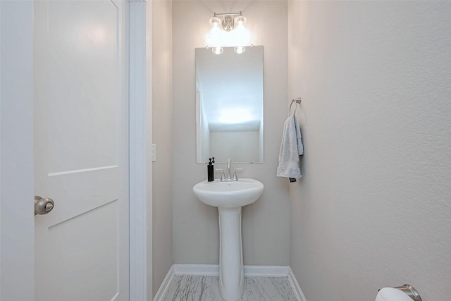 bathroom with marble finish floor and baseboards