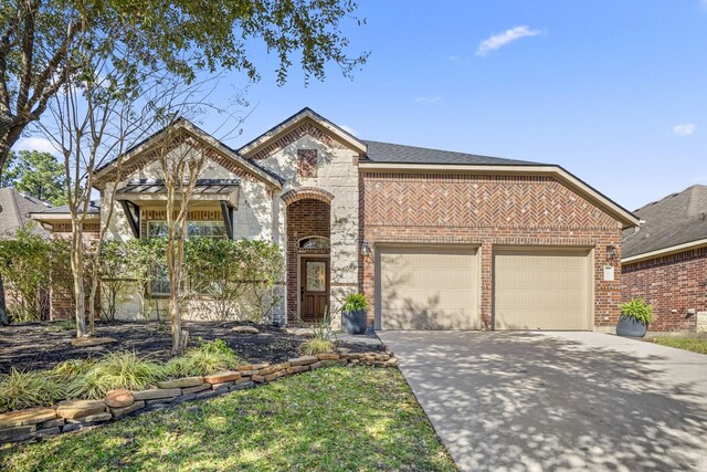 view of front of home with a garage, concrete driveway, brick siding, and stone siding