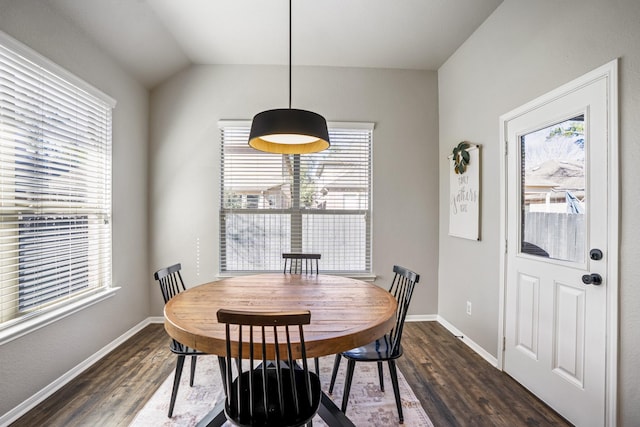 dining area featuring vaulted ceiling, dark wood-style flooring, and baseboards