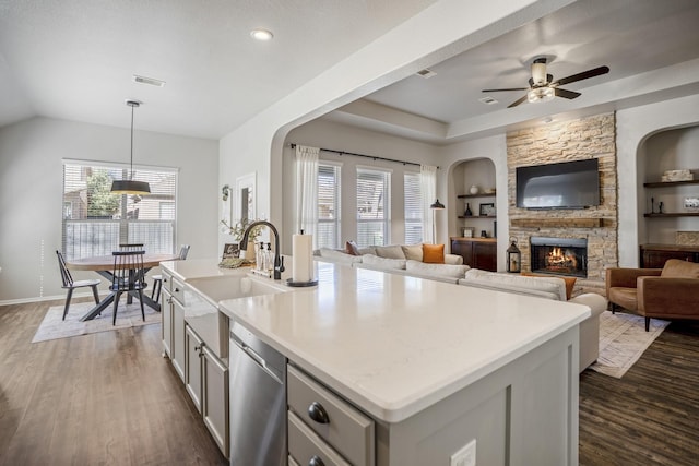 kitchen with built in features, a healthy amount of sunlight, a sink, and stainless steel dishwasher