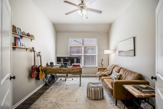 home office featuring lofted ceiling, dark wood finished floors, a ceiling fan, and baseboards