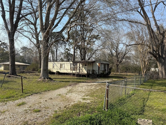 view of front of home with driveway, a front yard, fence, and a wooden deck