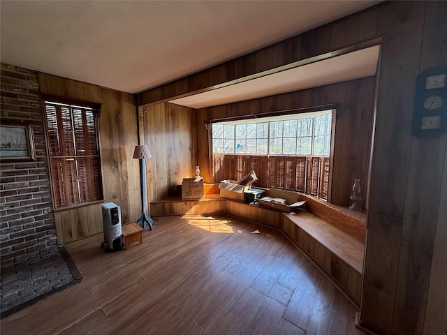 living area with wooden walls and wood finished floors