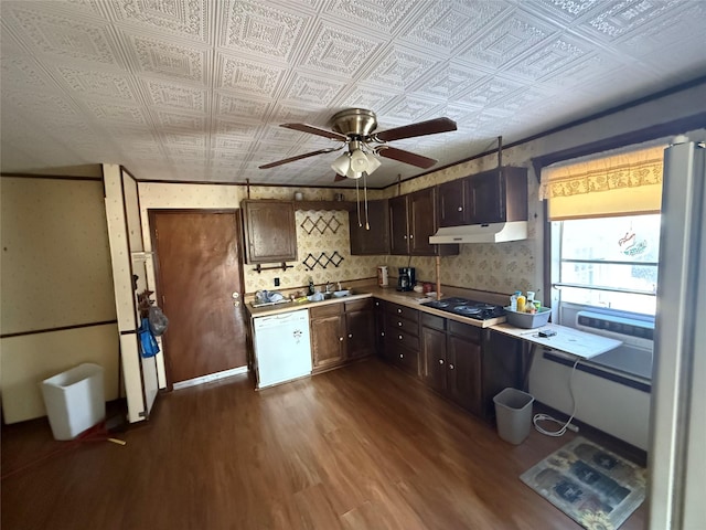 kitchen with under cabinet range hood, light countertops, dishwasher, an ornate ceiling, and wallpapered walls