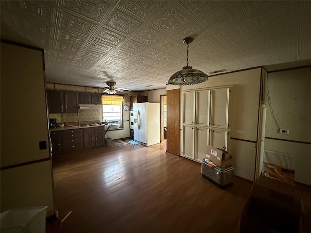 kitchen with an ornate ceiling, dark wood-style floors, visible vents, freestanding refrigerator, and dark brown cabinetry