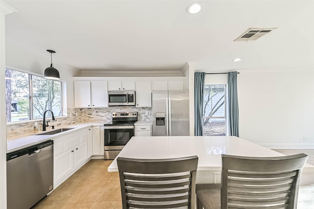 kitchen with visible vents, appliances with stainless steel finishes, a sink, light countertops, and backsplash