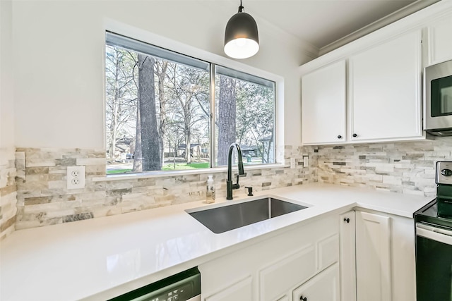 kitchen featuring stainless steel appliances, white cabinetry, a sink, and decorative backsplash