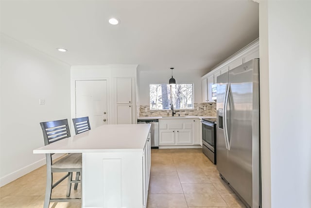 kitchen featuring tasteful backsplash, appliances with stainless steel finishes, light tile patterned flooring, a sink, and white cabinetry