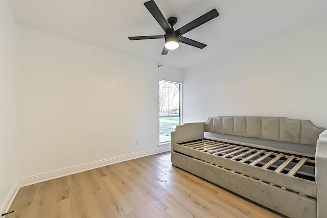 living room with light wood-type flooring, ceiling fan, and baseboards