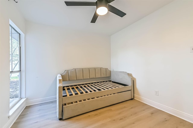 bedroom with ceiling fan, wood finished floors, and baseboards