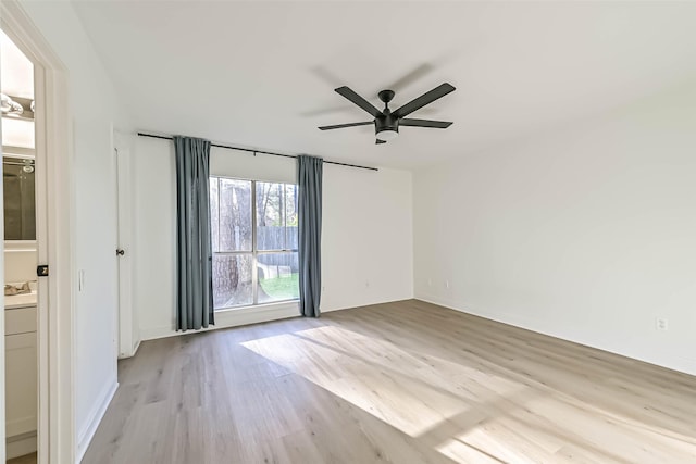 spare room featuring light wood-style flooring, baseboards, and a ceiling fan