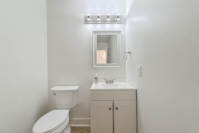 bathroom featuring baseboards, vanity, toilet, and tile patterned floors