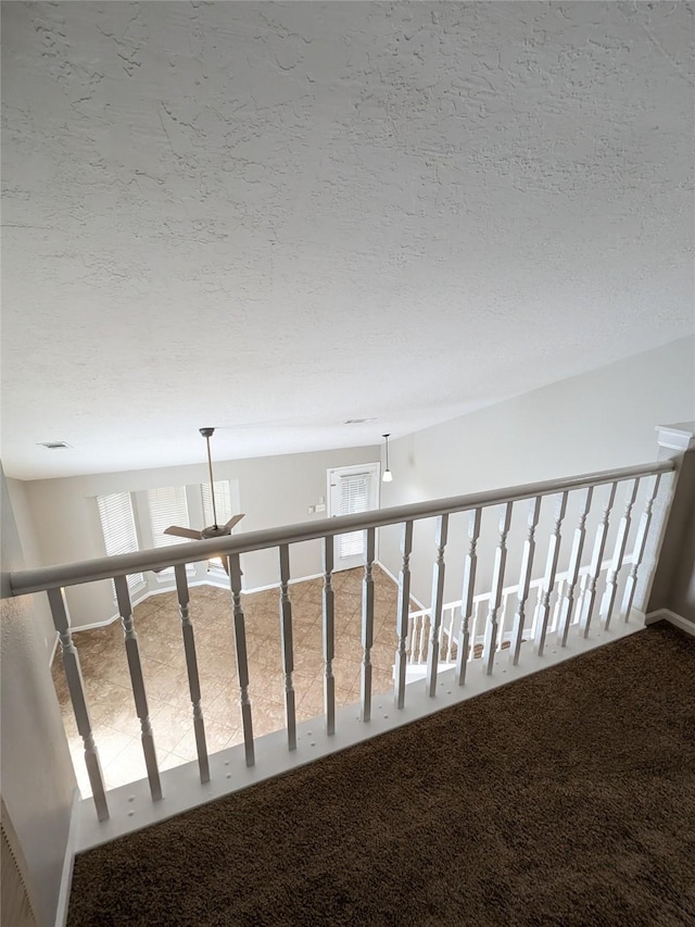 hallway featuring carpet floors and a textured ceiling