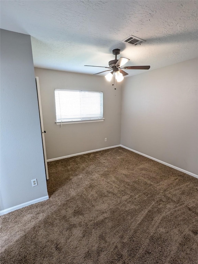 carpeted spare room with a ceiling fan, baseboards, visible vents, and a textured ceiling