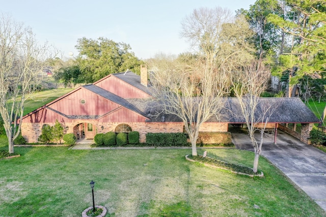 exterior space with a carport, a chimney, a front lawn, and concrete driveway