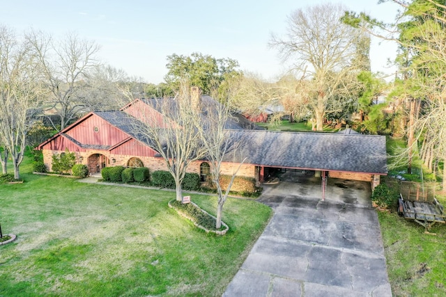 view of front of property with a shingled roof, concrete driveway, and a front lawn