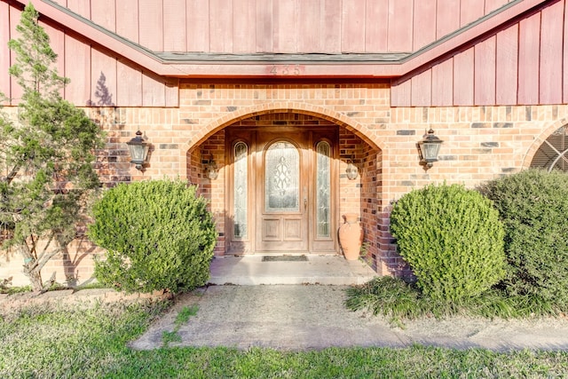 doorway to property with brick siding