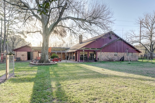 exterior space featuring a yard, a chimney, and brick siding