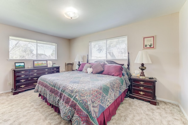 bedroom with light colored carpet, baseboards, and multiple windows