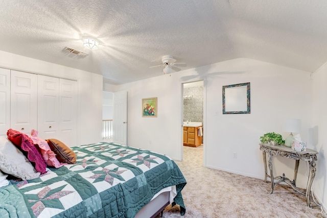 bedroom with a textured ceiling, carpet floors, a closet, and visible vents