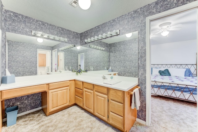 ensuite bathroom featuring ensuite bathroom, vanity, visible vents, and wallpapered walls