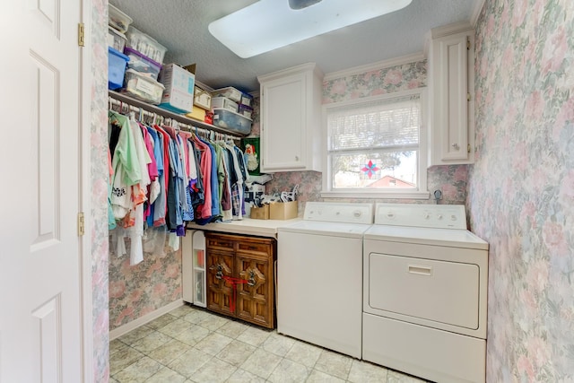 laundry room with cabinet space, a textured ceiling, washer and dryer, baseboards, and wallpapered walls