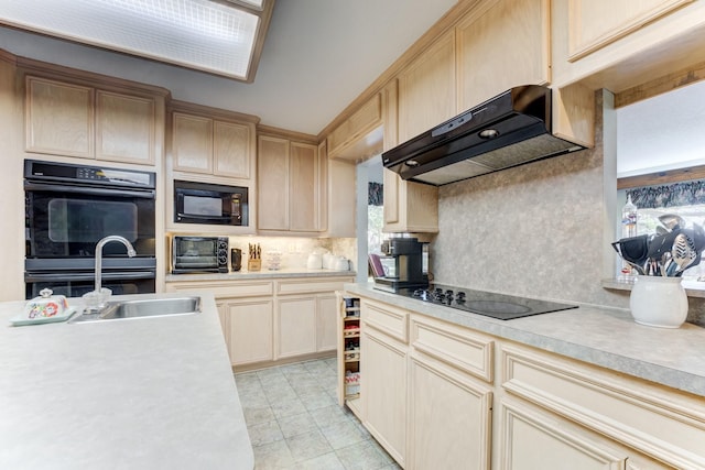 kitchen featuring black appliances, premium range hood, light countertops, and light brown cabinetry